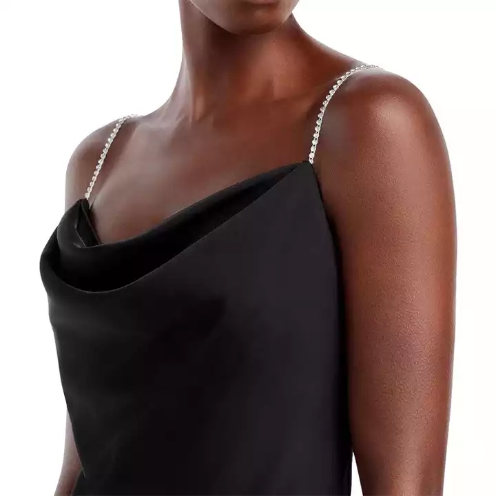 Gaun hitam dengan garis leher longgar memberikan kesan elegan namun seksi.